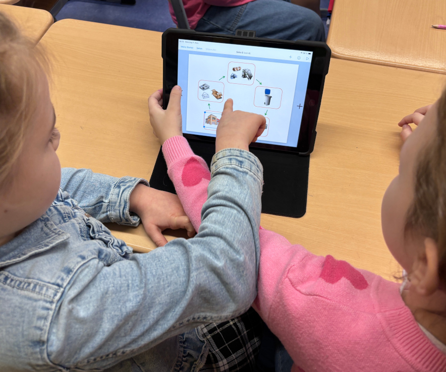 Zwei Kinder tippen auf das Display eines Tablets
