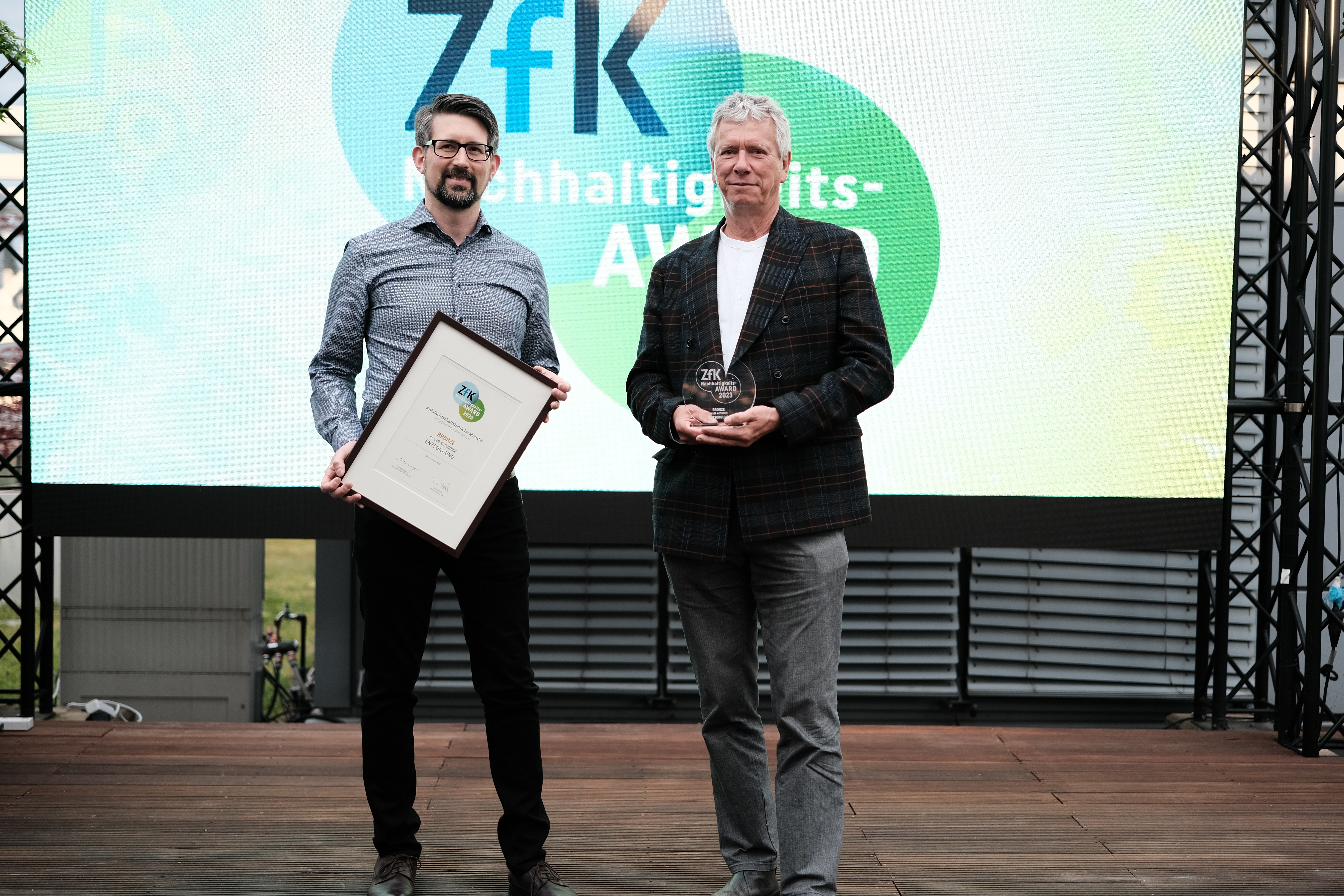 awm-Nachhaltigkeitspädagoge Nicolai Meyer (links) und Betriebsleiter Patrick Hasenkamp (rechts) nahmen die Auszeichnung in Berlin entgegen. 