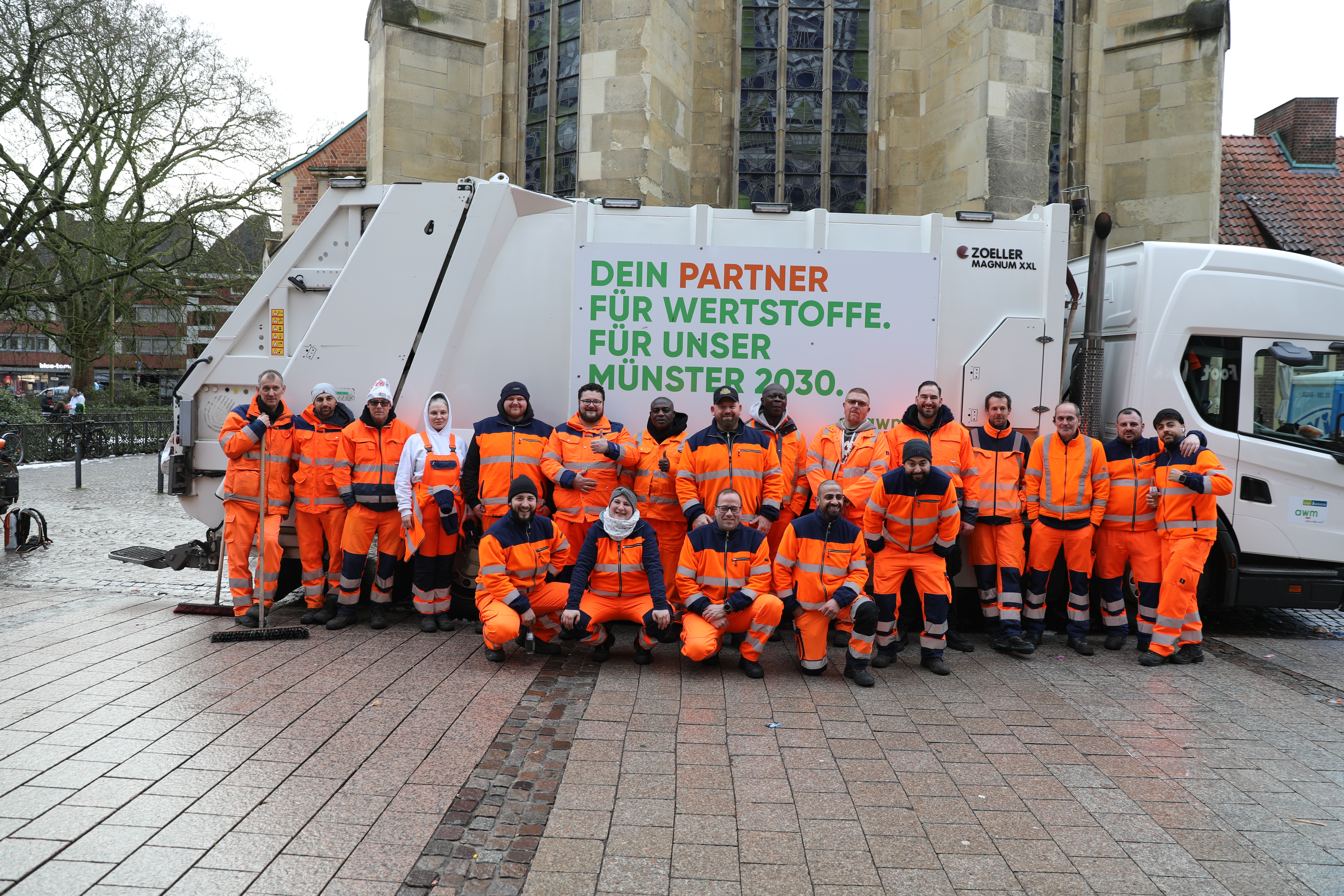Mitarbeitende der Abfallwirtschaftsbetriebe Münster vor einem Entsorgungsfahrzeug