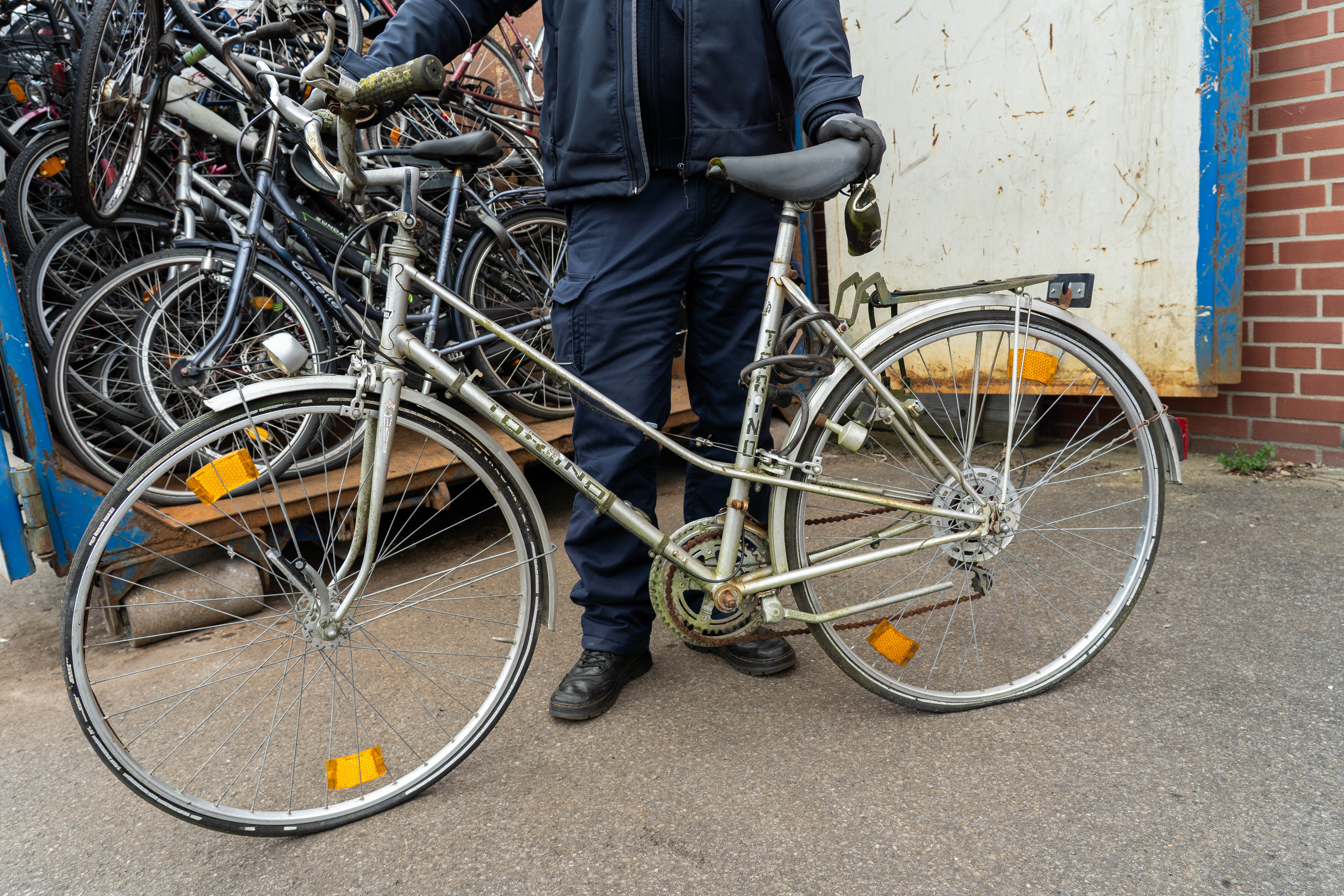 Ein städtischer Mitarbeiter präsentiert ein Schrottrad.